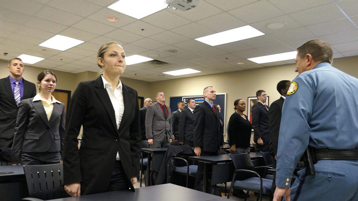 Recruit Kendall Buford, front left, stood at attention as Police Chief Ronnie Bastin, right, and the command staff (not pictured) began to file out of the room after being introduced to the Police Academy recruit class of 2012 on Wednesday, Jan. 4, 2012 at the Division of Police Roll Call and Training Facility 1795 Old Frankfort Pike in Lexington, Ky.  The media was introduced to the 2012 Lexington Division of Police class of 27 new recruits participating in the 2012 Police Academy.  They will complete nearly 11 months of training, which includes eight months of classroom and six weeks of street training.  Photo by David Perry | Staff


