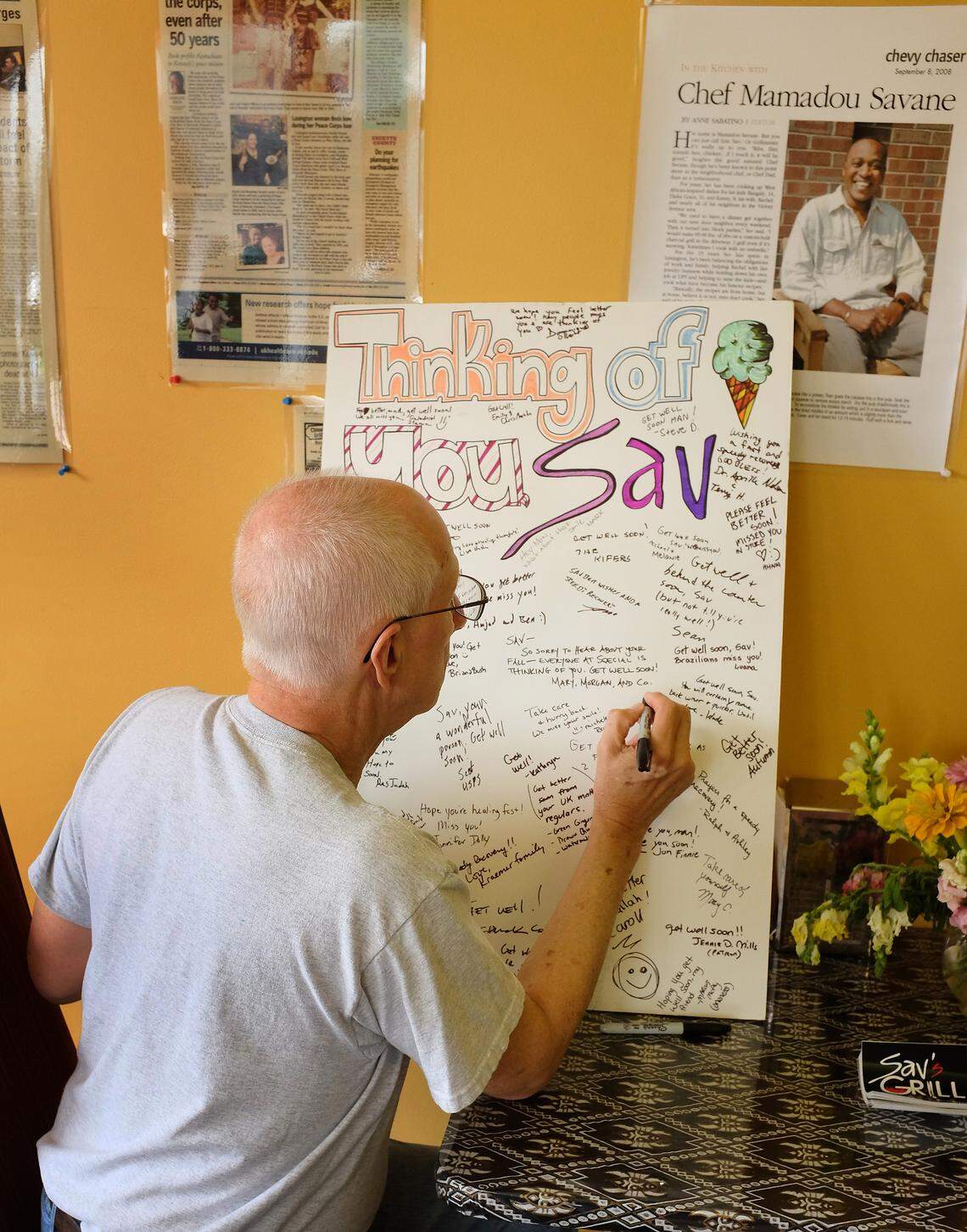 Customer Allan Hetzel signed a get-well card Tuesday for Mamadou “Sav” Savané, owner of Sav’s Grill & West African Cuisine, who badly turned himself June 3 while cooking. “He’s just the nicest guy,” Hetzel said of Savané. “He would do anything for you.”