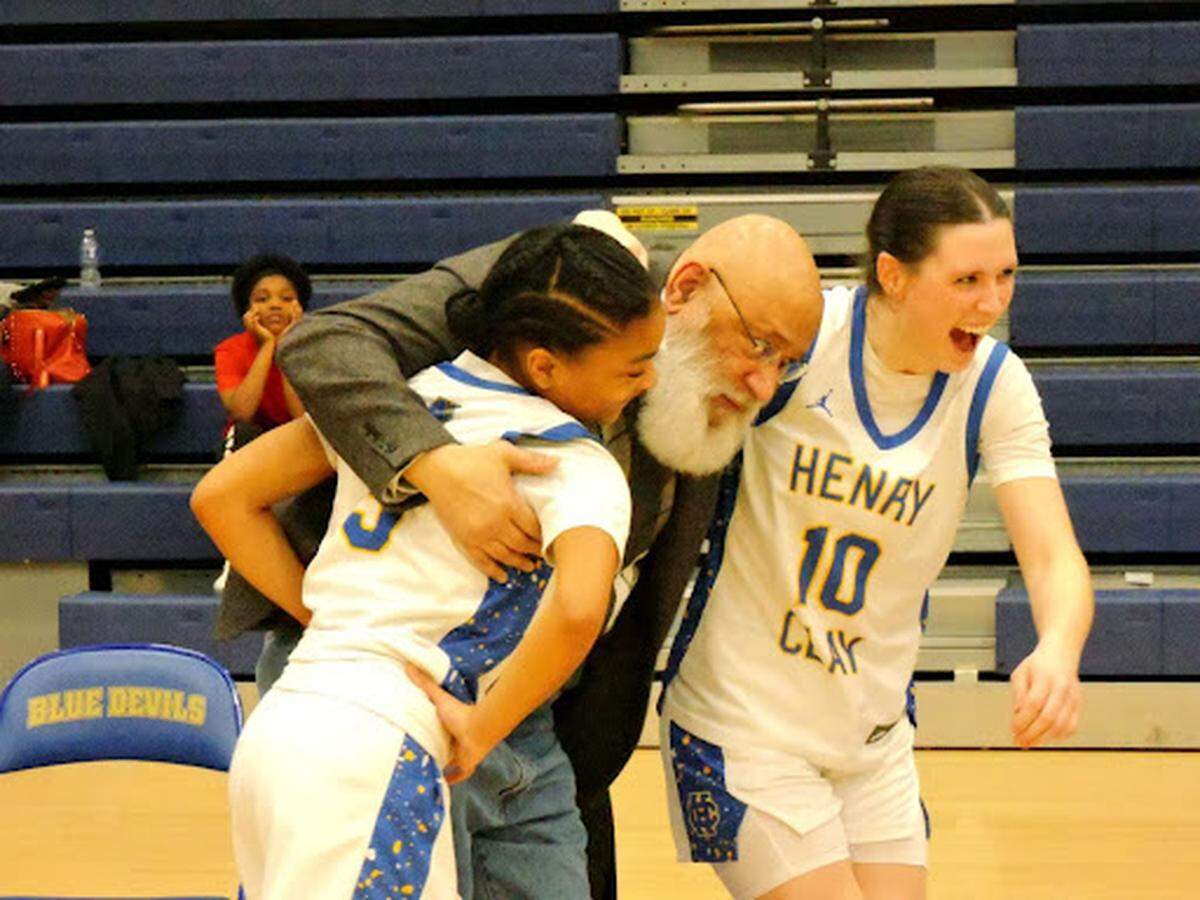 Frankfort basketball coach Maurice Garrard, center, flanked by Henry Clay’s Brinlee Dumphord, his granddaughter, and Alli Stone (10), a former player in his AAU program.