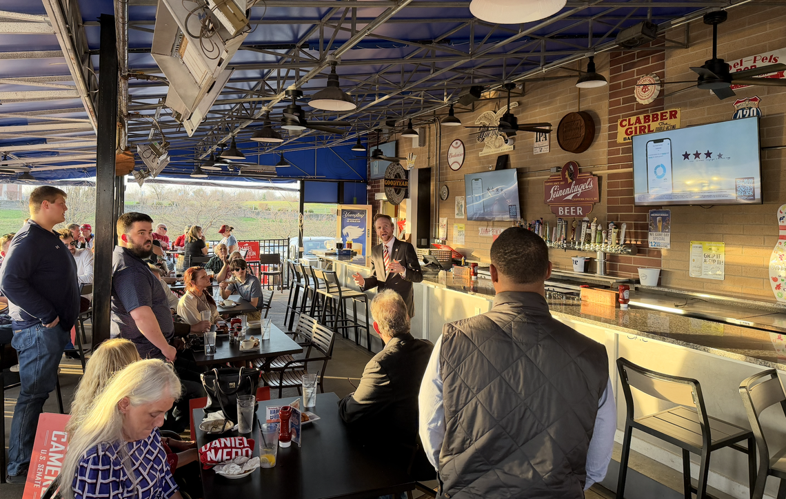 U.S. Senate candidate Daniel Cameron listens as Rep. T.J. Roberts, R-Burlington, introduces him at a rally in Florence, Ky.