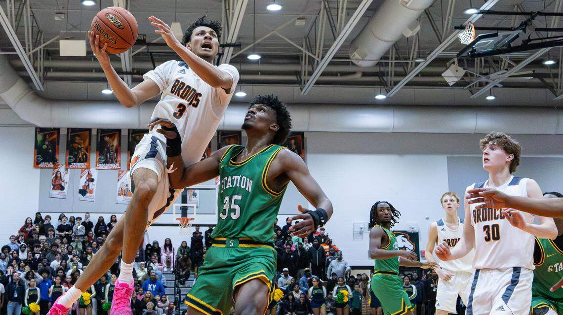 Douglass's DeMarcus Surratt (#3) leaps over Bryan Station's Taeshawn Adams (#35) for a two-point layup during the Bryan Station and Frederick Douglass boys basketball game at Frederick Douglass High School on Jan. 13, 2026, in Lexington, Ky.