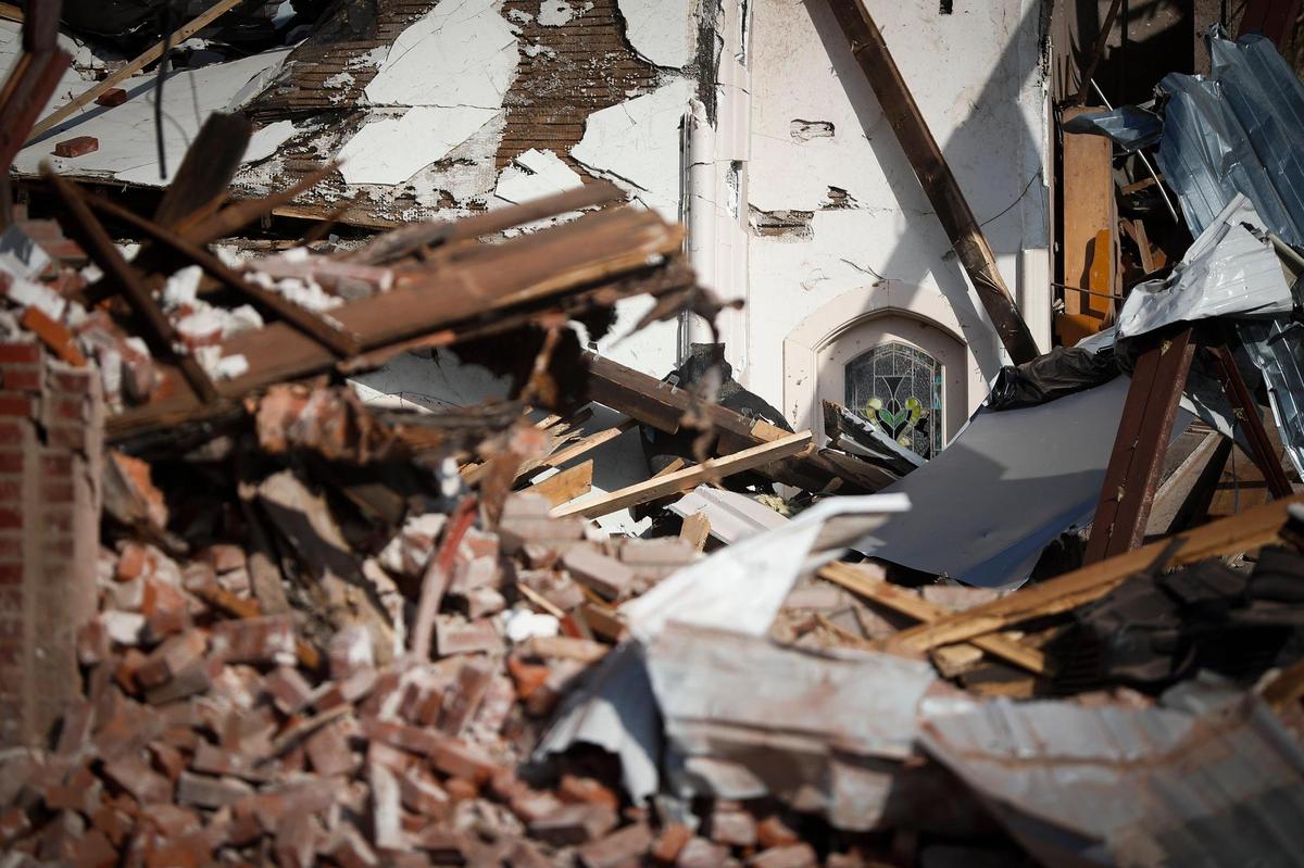 A stained glass window pane sits undamaged in the otherwise destroyed remains of the First Presbyterian Church in Mayfield, Ky., Tuesday, Dec. 14, 2021.