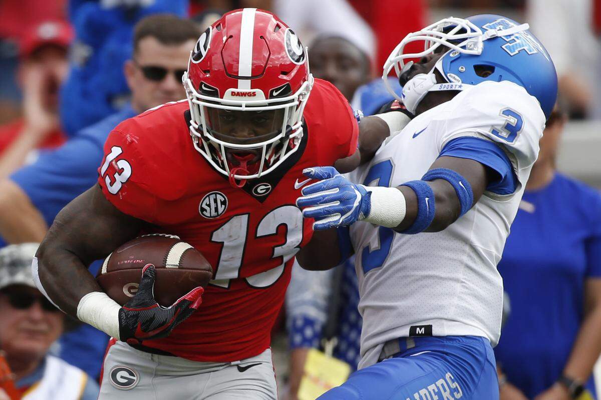 Georgia running back Elijah Holyfield, right, leads the Bulldogs in rushing with 559 yards. He is the son of boxing’s four-time heavyweight champion of the world, Evander Holyfield.