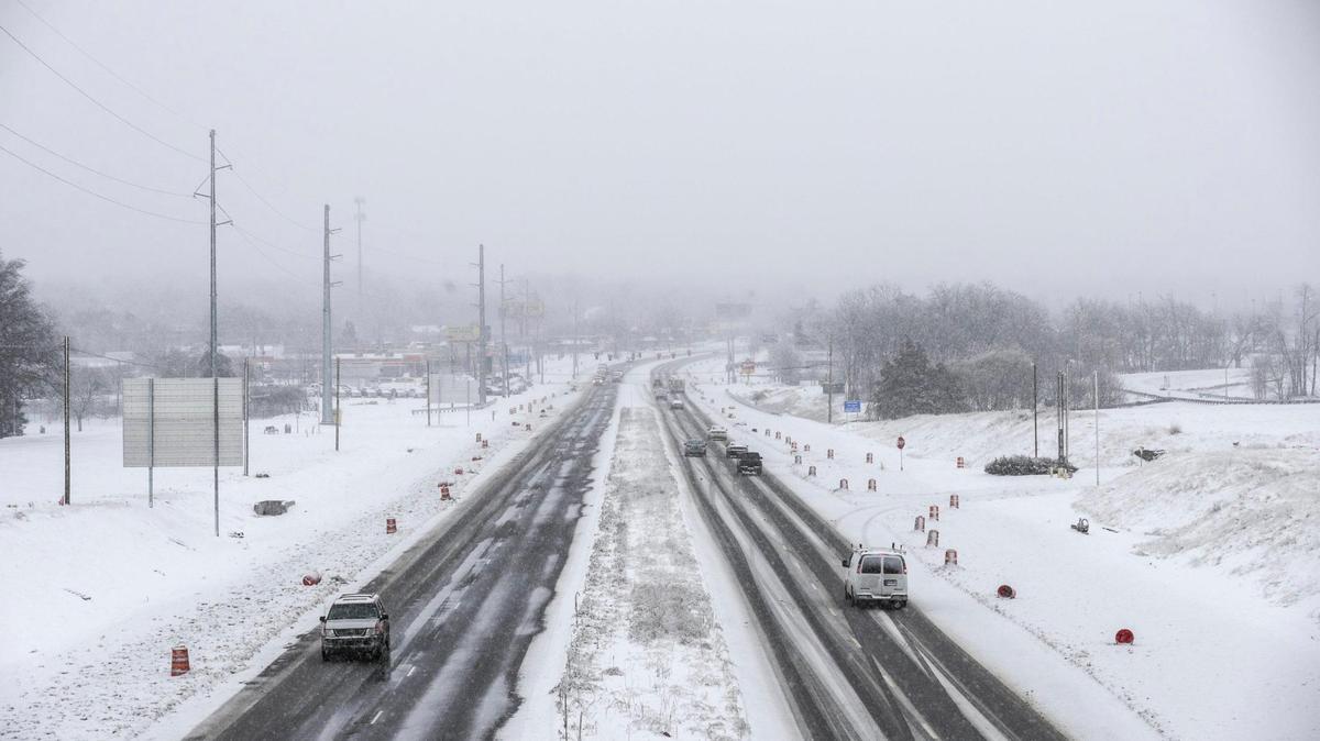 Vehicles drove on Lexington’s New Circle Road near the interchange with Newtown Pike after crews partially cleared lanes.