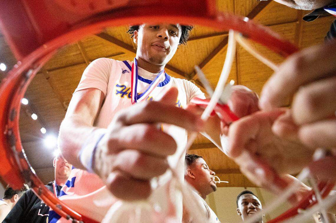 Henry Clay’s Aziel Blackwell helps cut down the nets after the Blue Devils secured their first berth in the Boys’ Sweet 16 since 2005 by winning the 11th Region Tournament on Monday night.