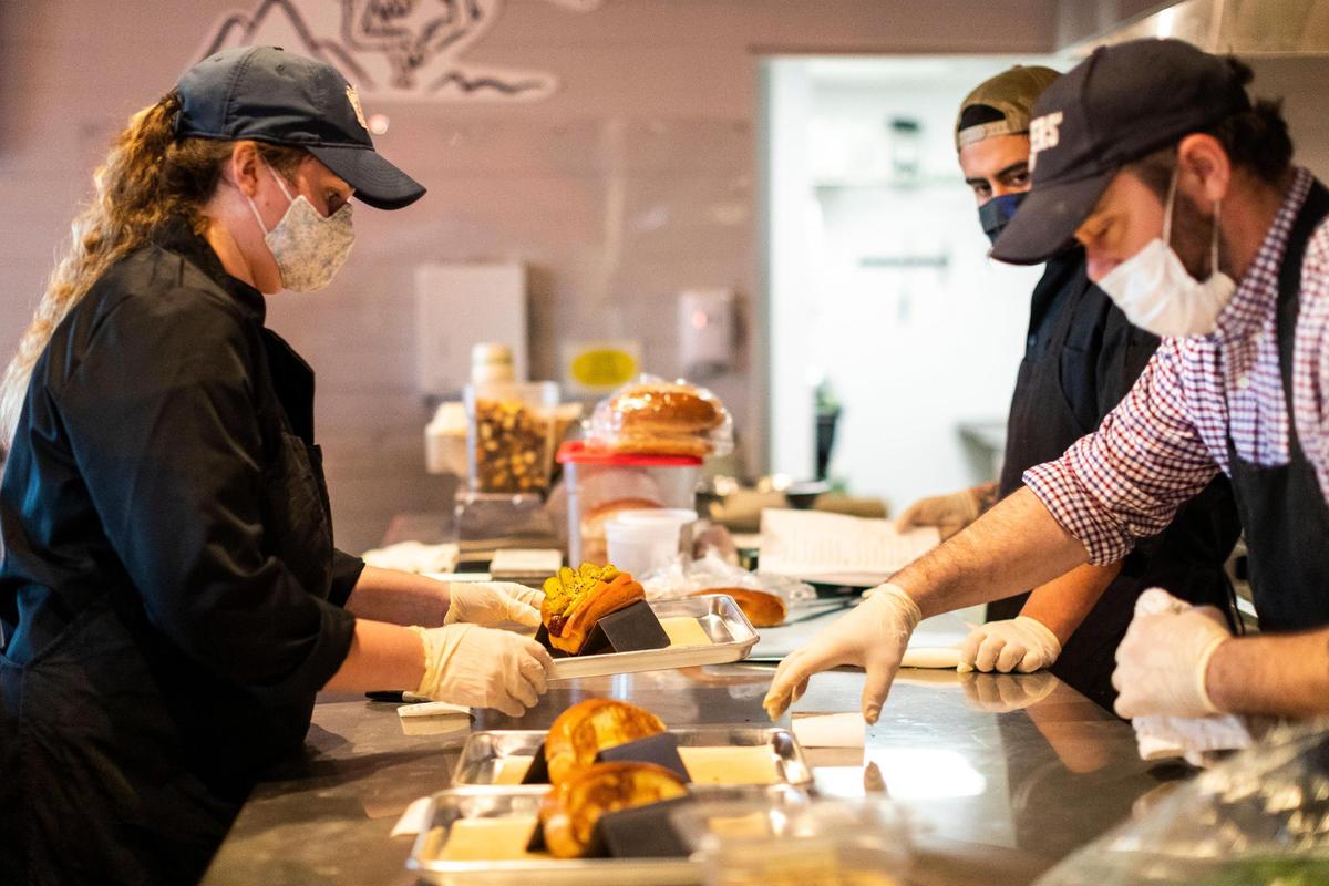 Kitchen staff at Boonedogs prepare meals during a Jan. 20 soft opening at their location on Old Richmond Road. Some of the gourmet hot dog offerings include the Kentucky Dog, Hambassador, Footlong, Sausage Chorizo and Italian.