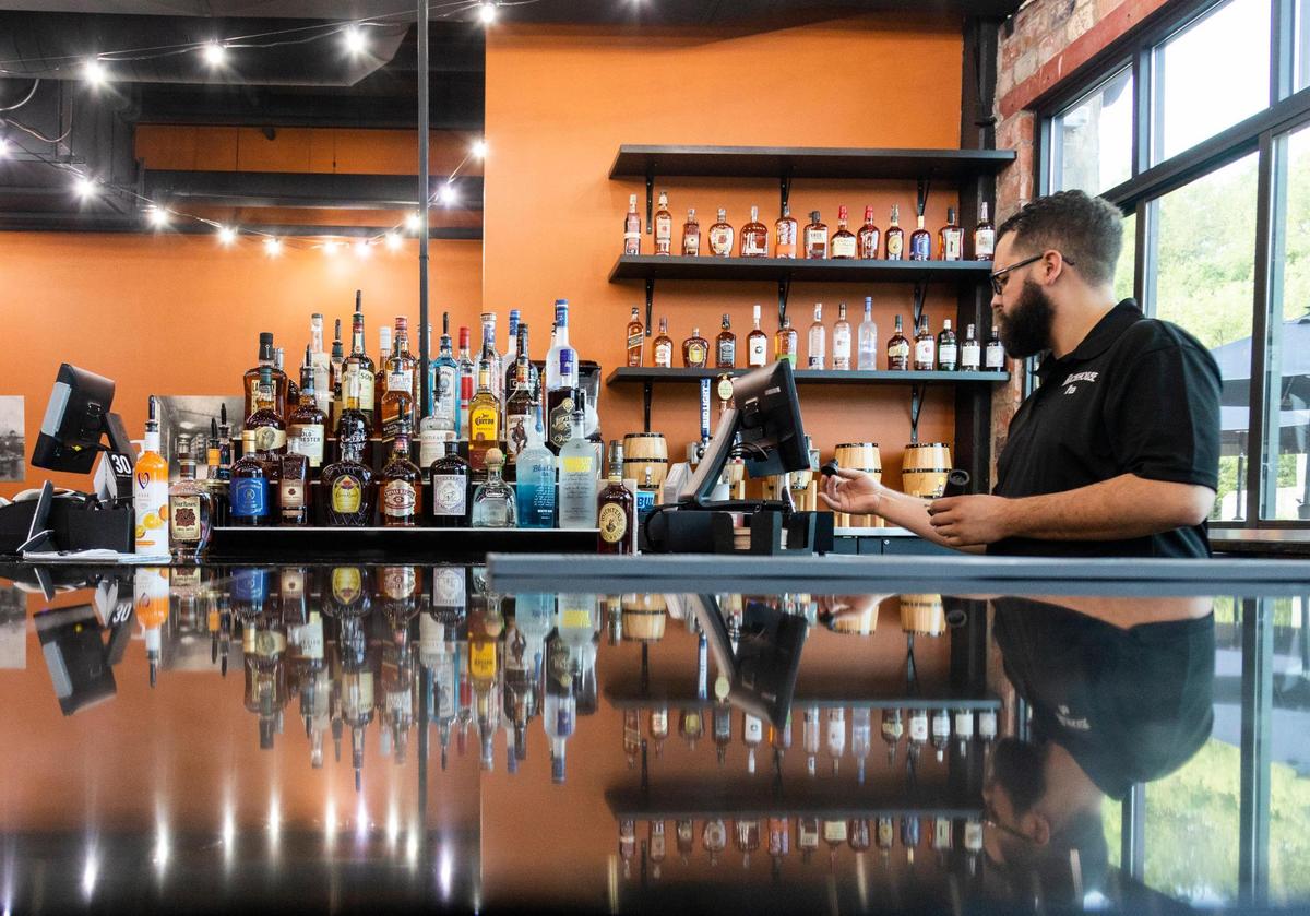 Manager and bartender Austin Lark worked behind the bar at Rickhouse Pub during its opening week at the Distillery District in Lexington. The pub has a full bar and lots of canned beers.