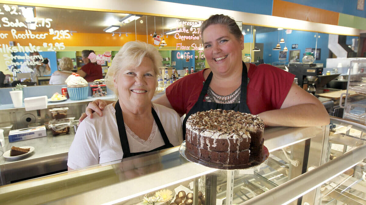 Kathleen Sullivan helps out her daughter Jan Sullivan at Bakery, Blessings & Bookstore @ the Bar. That's a Mississippi mud cake. The recipe for the cake is on Page B4.  