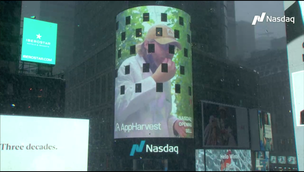 Founder and CEO Jonathan Webb eats an AppHarvest tomato in a video message displayed in Times Square on Monday.