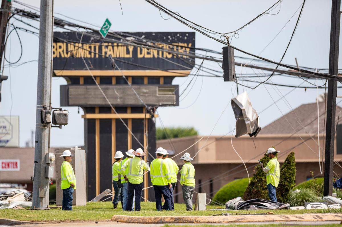 Electrical construction workers wait to clear debris from a fallen power line on Sunday, May 18, 2025, on U.S. Route 27 in Somerset, Ky.