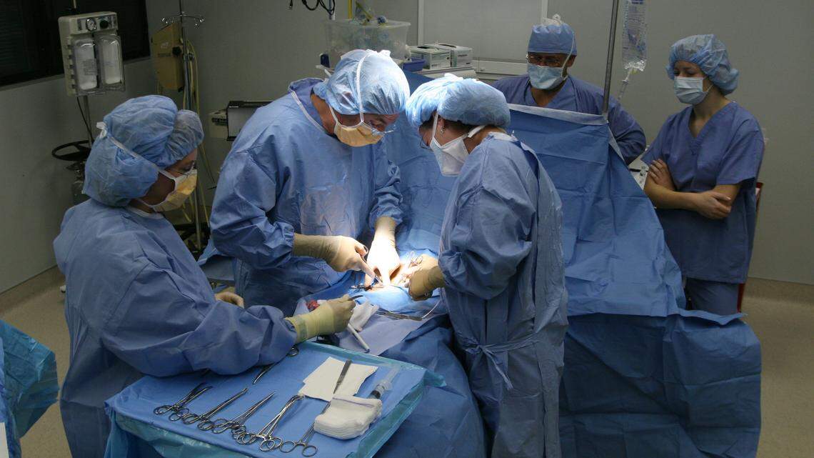 In 2006, Dr. Paul Kearney, center left, a surgeon who is director of trauma and critical care at the University of Kentucky, performed a hernia repair in Lexington. Fifteen outpatient surgeries performed that day were provided for free as part of the Surgery on Sunday program which offered help for under or uninsured patients. From left are Belle Cord, certified registered nurse first assistant, Dr. Kearney, Shirley Ramsey, CRNFA, Richard Dickens, certified registered nurse anesthetist, and prenursing student Lisa Pippen.