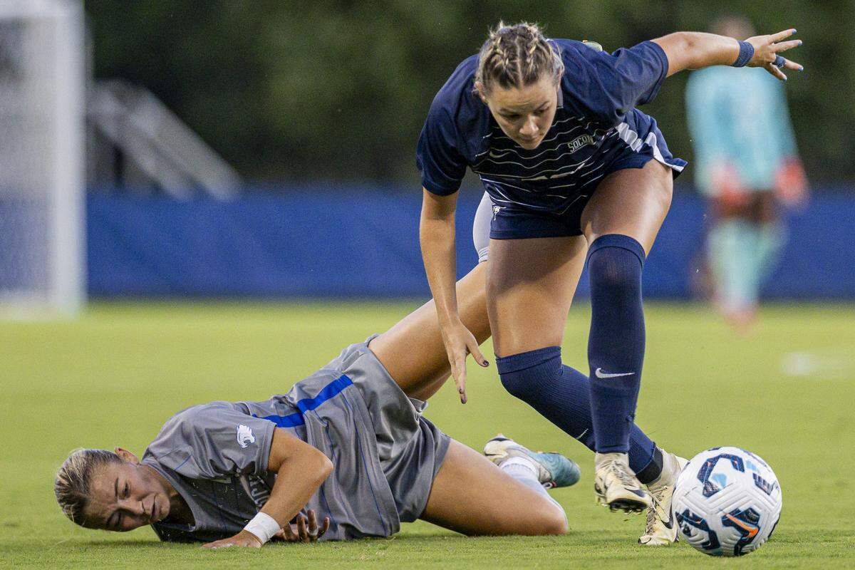 ETSU defender McKlain Jones dribbles past Kentucky midfielder Sophie Harlan after pushing her down during the soccer game vs. ETSU on Thursday, Aug. 21, 2025, at Wendell and Vickie Bell Soccer Complex in Lexington, Ky. 