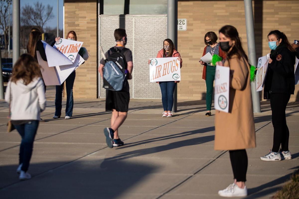 Students are greeted by teachers and staff with signs as they make their way off buses returning to in-person learning at Frederick Douglass High School in Lexington, Ky, Monday, March 8, 2021. Close to 80 percent of the student body chose to return to in-person learning while 20 percent remain virtual according to Executive Principal Lester Diaz.