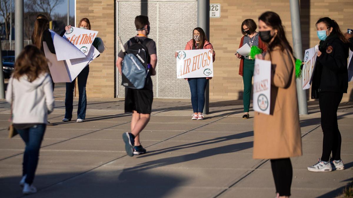 Students are greeted by teachers and staff with signs as they make their way off buses returning to in-person learning at Frederick Douglass High School in Lexington, Ky, Monday, March 8, 2021. Close to 80 percent of the student body chose to return to in-person learning while 20 percent remain virtual according to Executive Principal Lester Diaz.