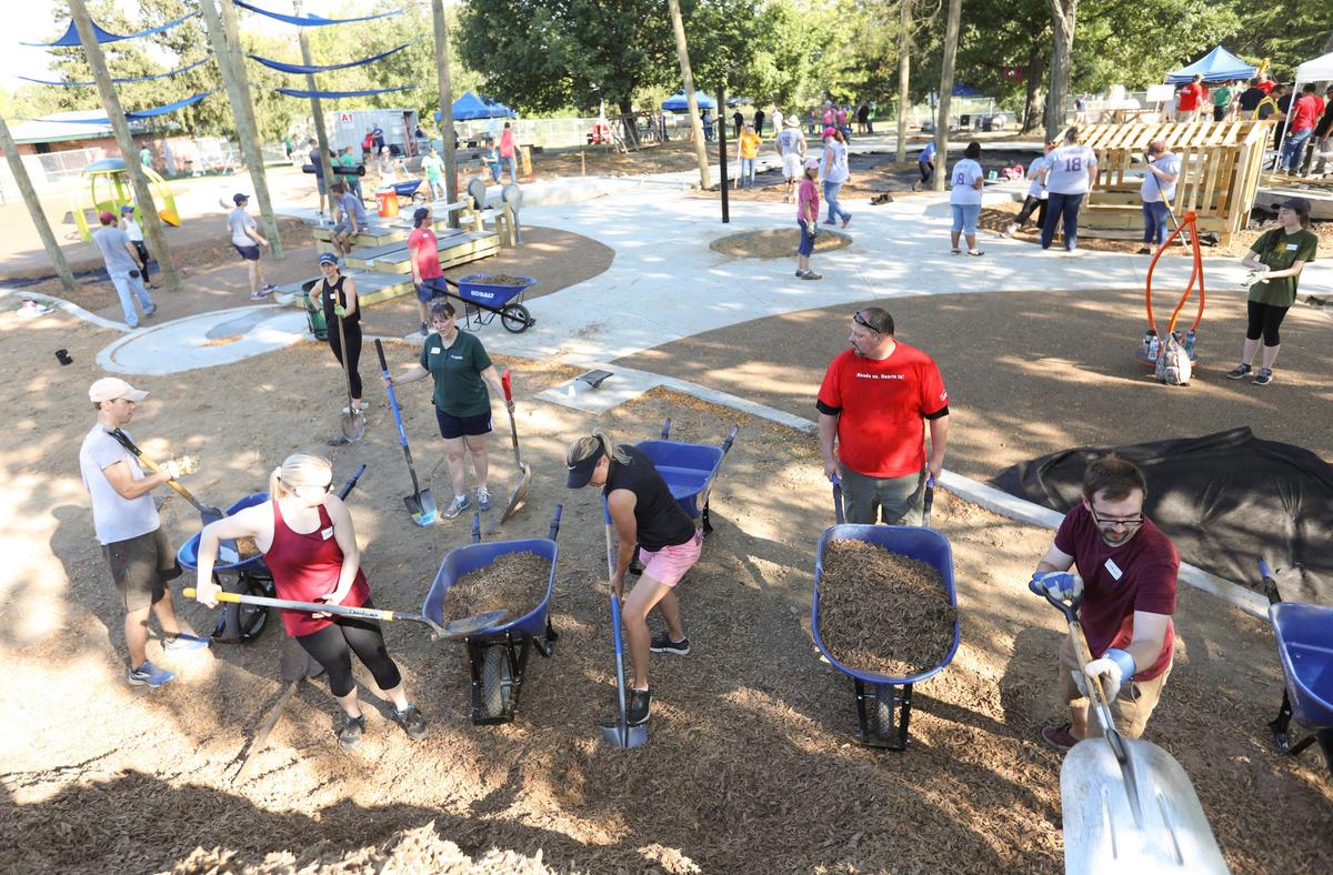 Volunteers help with the construction of a new playground at Shillito Park off of Reynolds Road on Wednesday, Sept. 18.