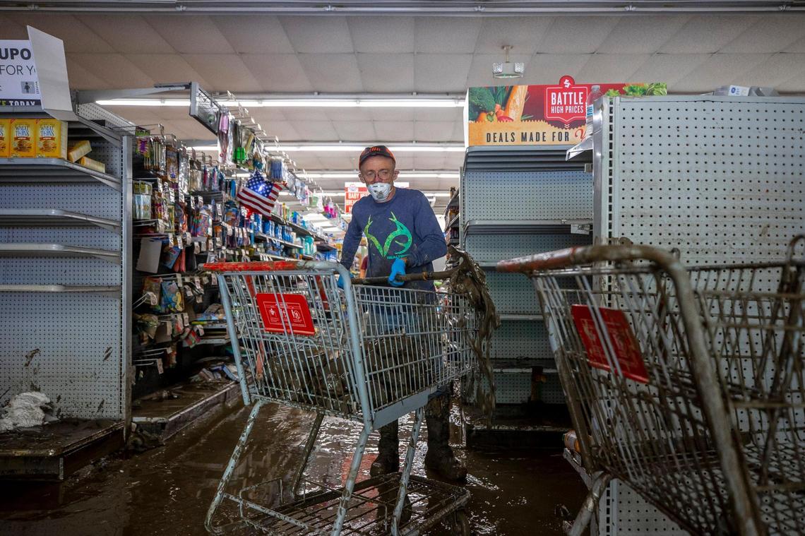David Sexton, an employee at Isom IGA in Isom, Ky., uses a shovel to scoop up product to be thrown out on Monday, Aug. 1, 2022. All the thousands of pounds of groceries inside the 16,000 square foot store were condemned by the health department.