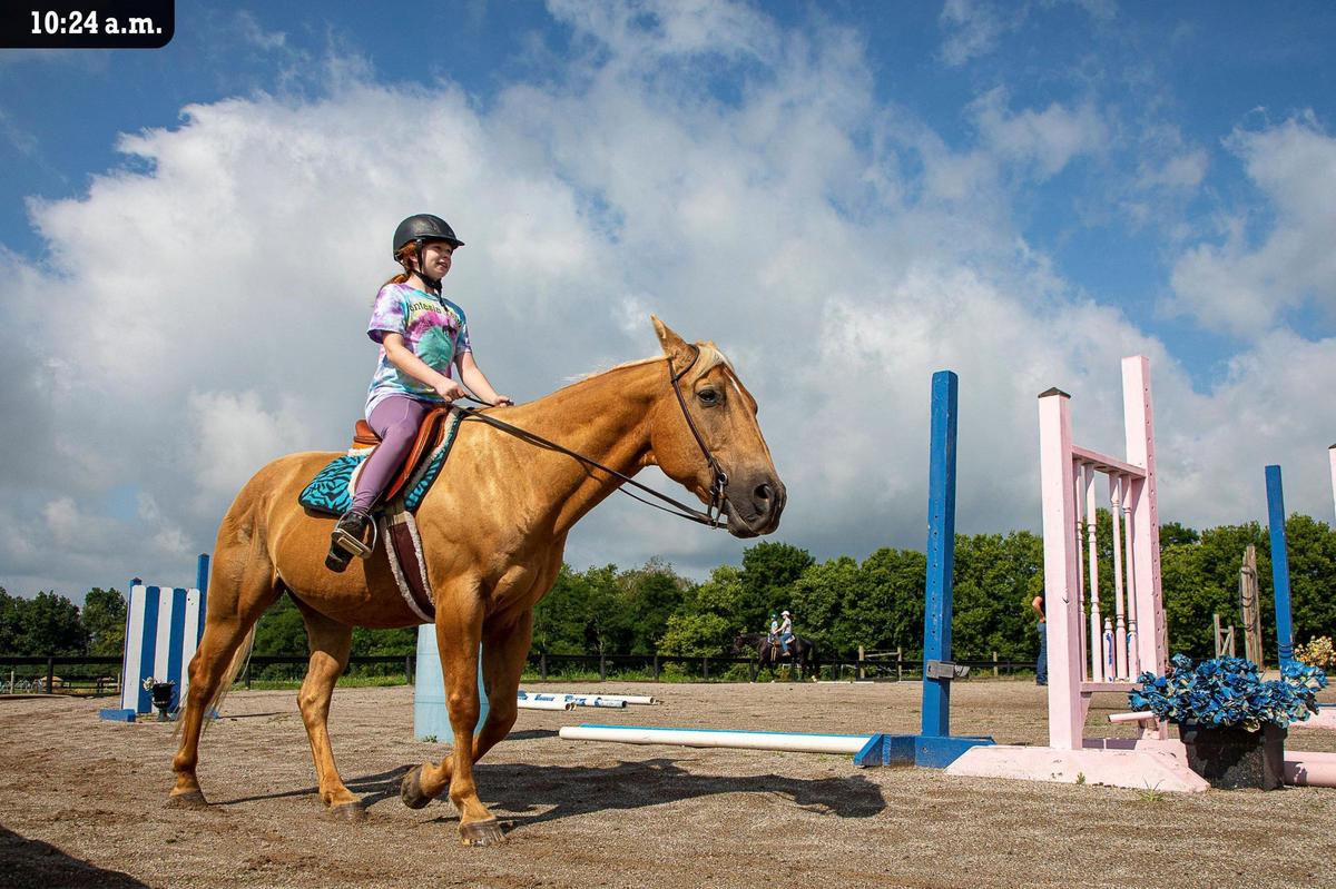 Emma Wright and her horse Kernel trot around the ring during a lesson with owner Debbie Grier at Fantasia Farm Friday, July 9. Wright has been riding for about three years. “She started here at summer camp and fell in love with it (riding),” said Emma’s mother, Kat Wright.