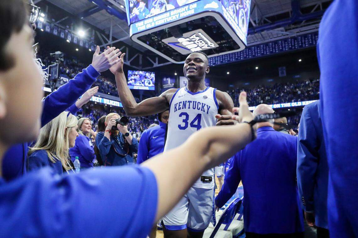 Kentucky’s Oscar Tshiebwe (34) high-fives fans while walking off the court after his team’s 76-67 defeat of Texas A&M on Saturday at Rupp Arena.