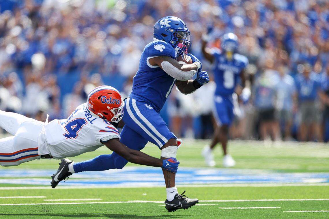 Kentucky running back Ray Davis (1) runs the ball for a first down before being tackled by Florida safety Jordan Castell during Saturday’s game at Kroger Field.