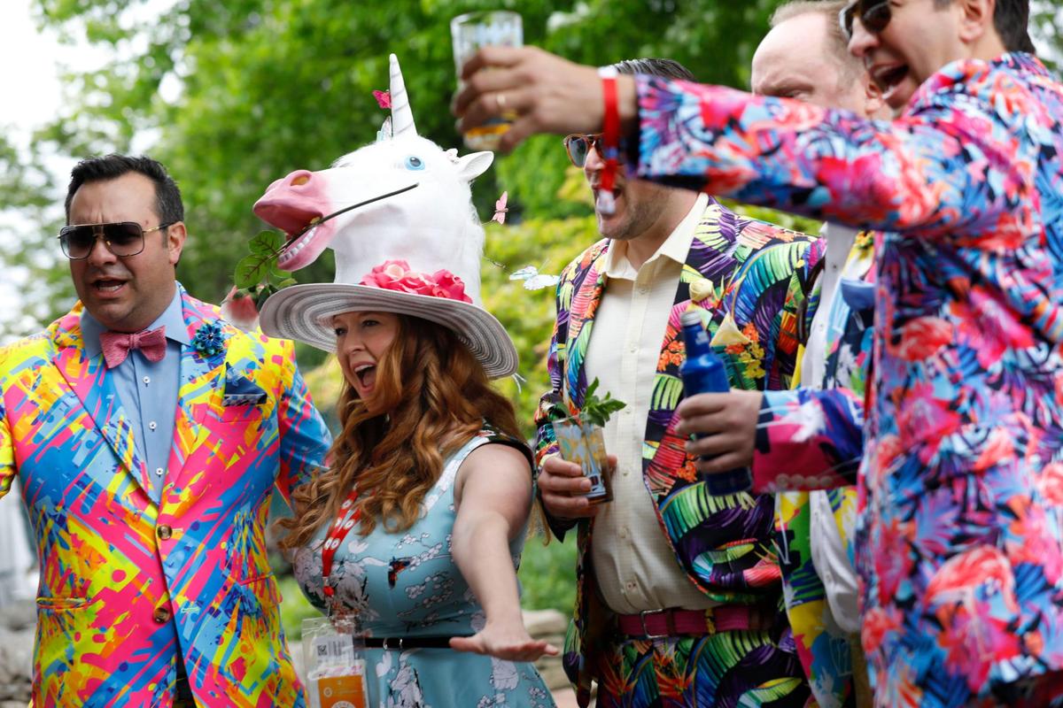 Kristen Piazza, from Tampa, poses for a picture in her unicorn hat with Nick Hansen, Chris Koeverly, Jeremy Hutchinson and Jon Hansen at Churchill Downs in Louisville, Ky., Saturday, May 7, 2022. She made the had herself after seeing a similar one a few years ago. The men’s suits were all by Loudmouth.