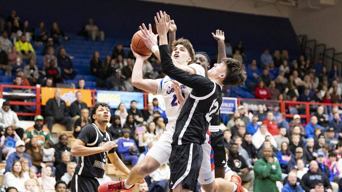 Madison Central’s Jake Feldhaus (20) goes up for a shot against Frederick Douglass’ Nate Coen during the Indians’ 69-66 win at Madison Central High School in Richmond on Jan. 23.