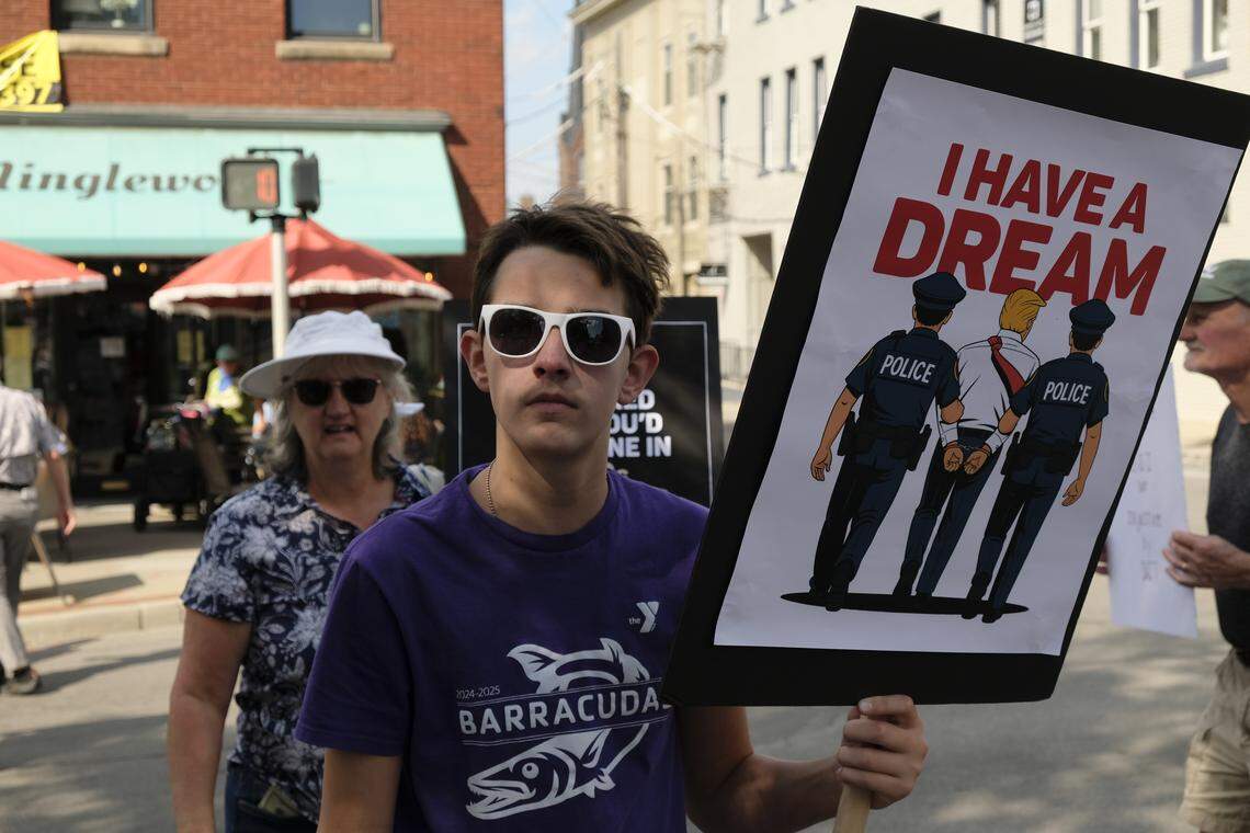 Andreu Brunk held a sign at the No Kings rally in Lexington, Ky., Oct. 18, 2025.