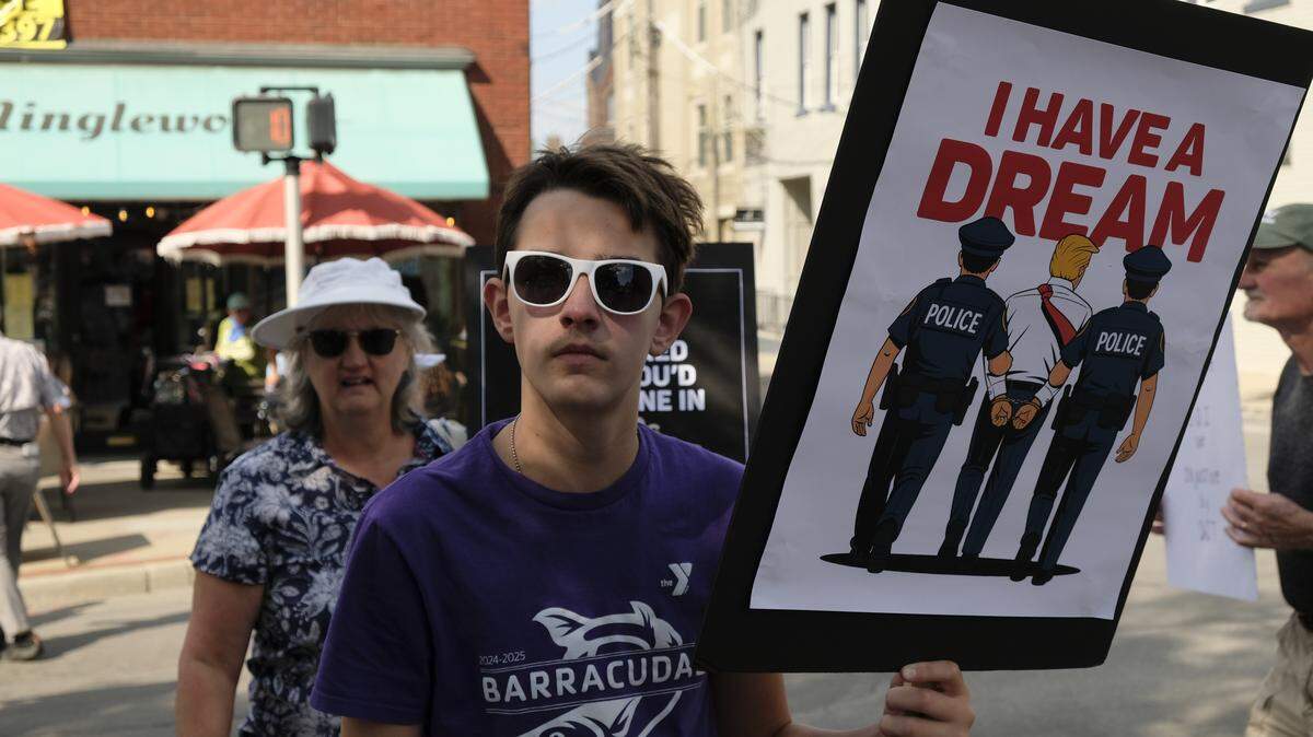 Andreu Brunk held a sign at the No Kings rally in Lexington, Ky., Oct. 18, 2025.