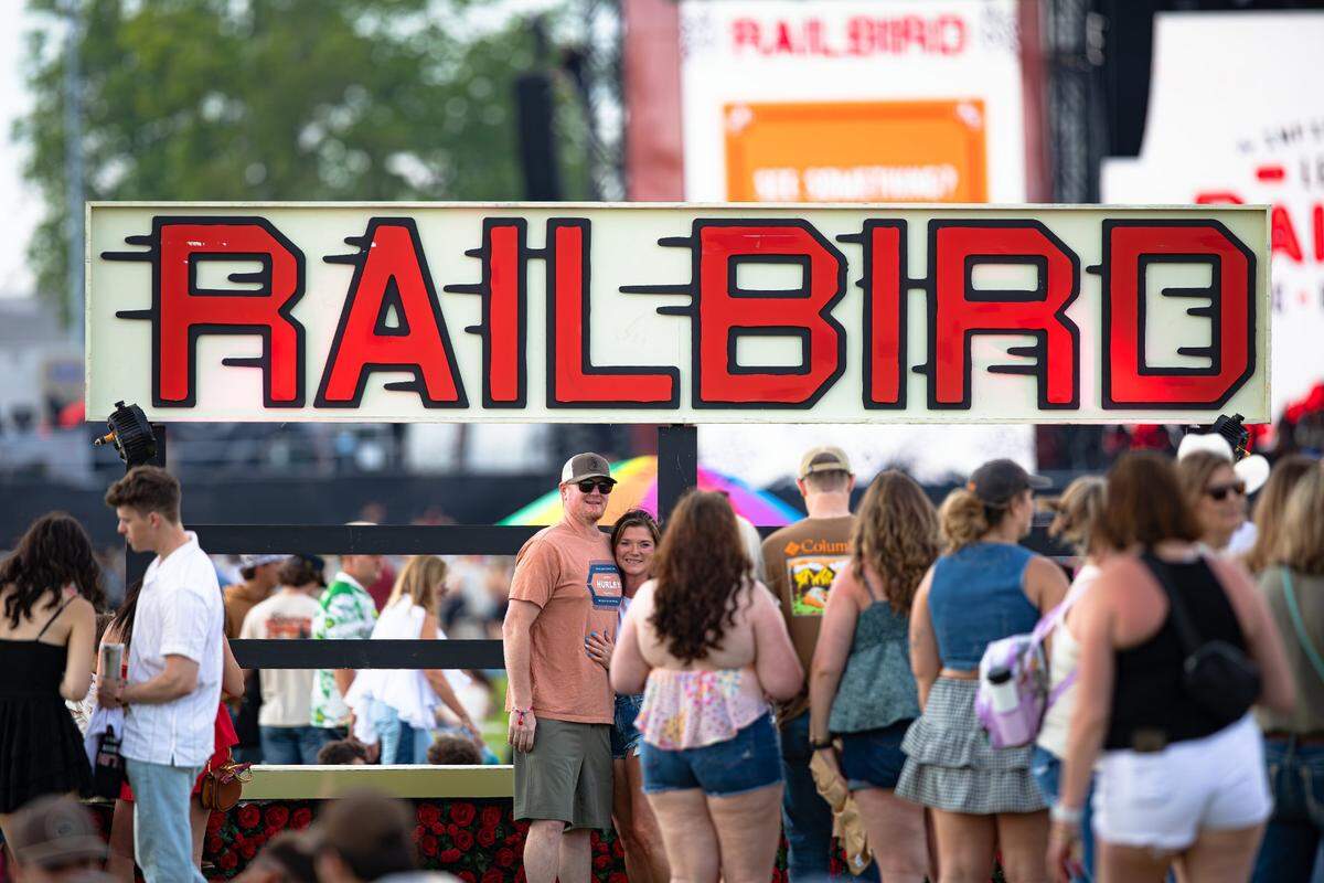 Festival-goers pose for a picture in front of Railbird signage during the 2025 Railbird music festival at The Red Mile infield on May 31, 2205, in Lexington, Ky.