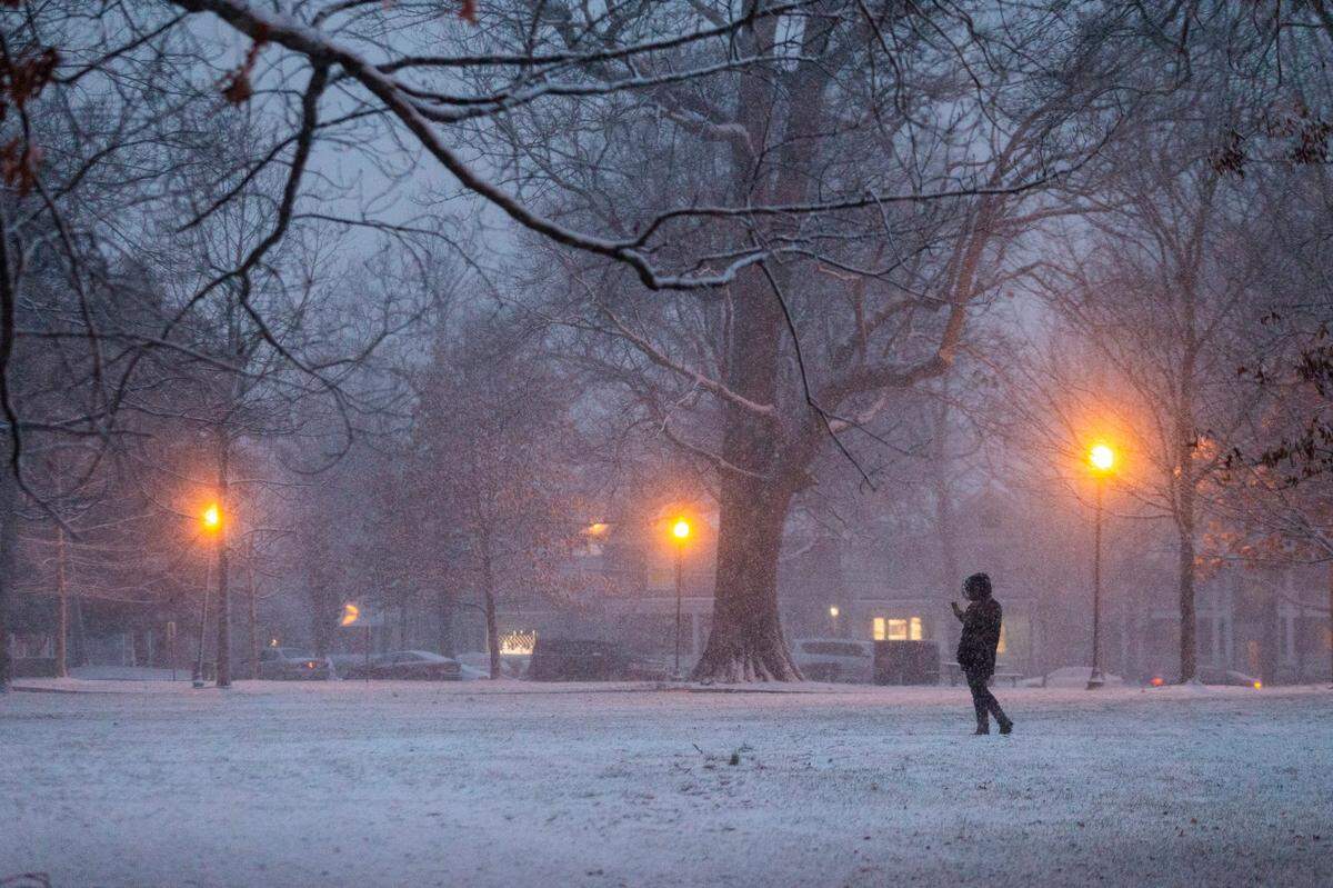 Pedestrians walk through Woodland park as snow falls in downtown Lexington, Ky., Wednesday, January 27, 2021. The National Weather Service has predicted a low of 20 degrees Wednesday night and a high of 32 Thursday.
