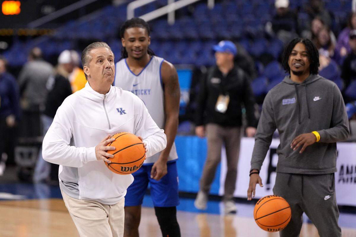 Kentucky Coach John Calipari takes a half-court shot during Thursday’s practice at Greensboro Coliseum.