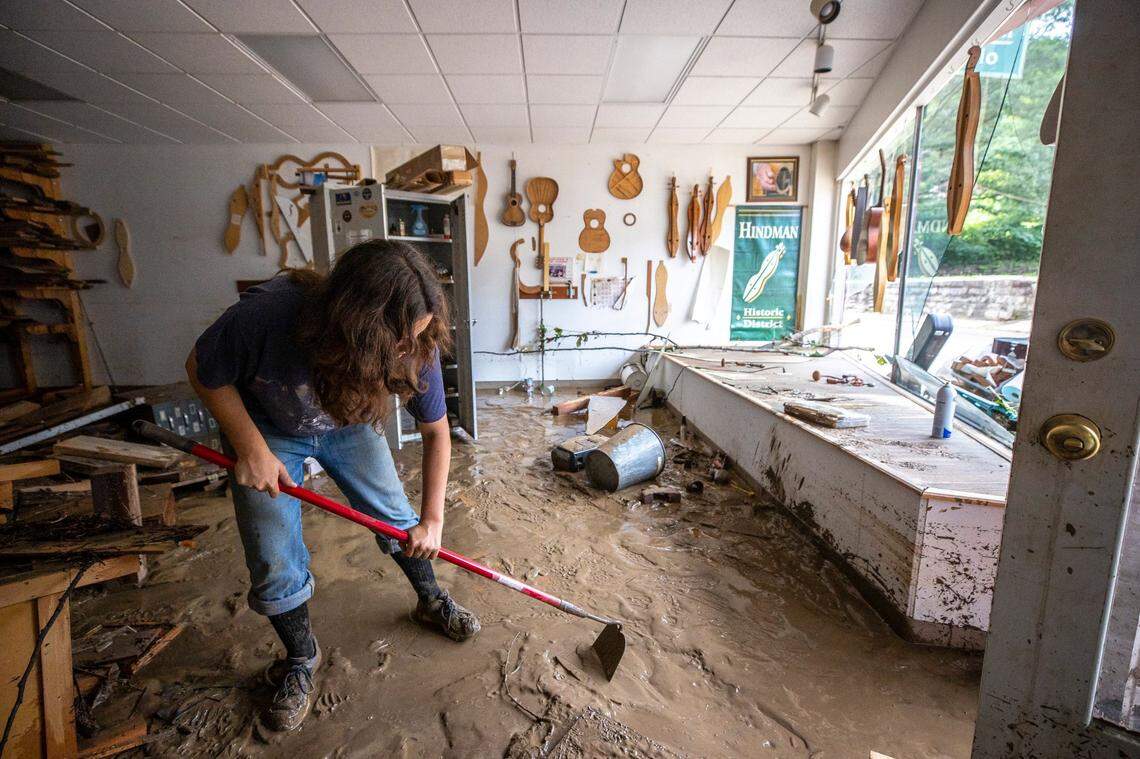 Willow Cartier helps clean out mud from the Appalachian School of Luthiery in Hindman, Ky, on Thursday, July 28, 2022, after a flood swept through the community in the early morning. 
