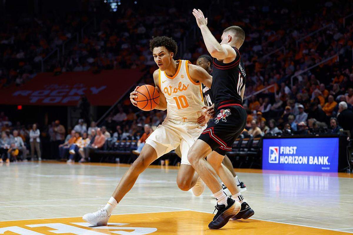 KNOXVILLE, TENNESSEE - DECEMBER 16: Nate Ament #10 of the Tennessee Volunteers dribbles the ball against Isaac McKneely #10 of the Louisville Cardinals during the second half of the game at Thompson-Boling Arena on December 16, 2025 in Knoxville, Tennessee. (Photo by Johnnie Izquierdo/Getty Images)