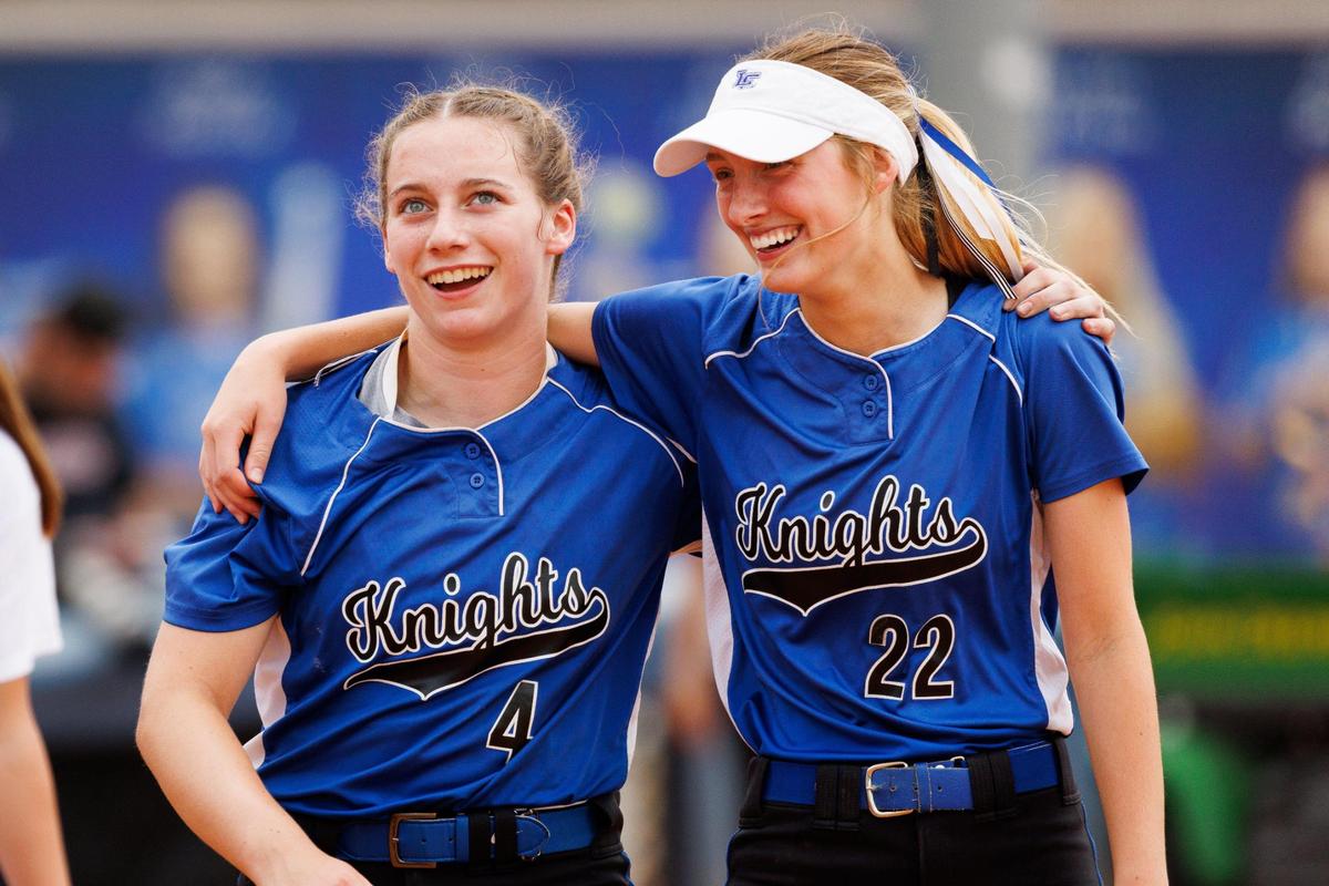Lexington Catholic’s Abby Hammond (4) and Lucy Nash (22) celebrate after the Knights’ win against Harrison County in the state softball quarterfinals on Friday.