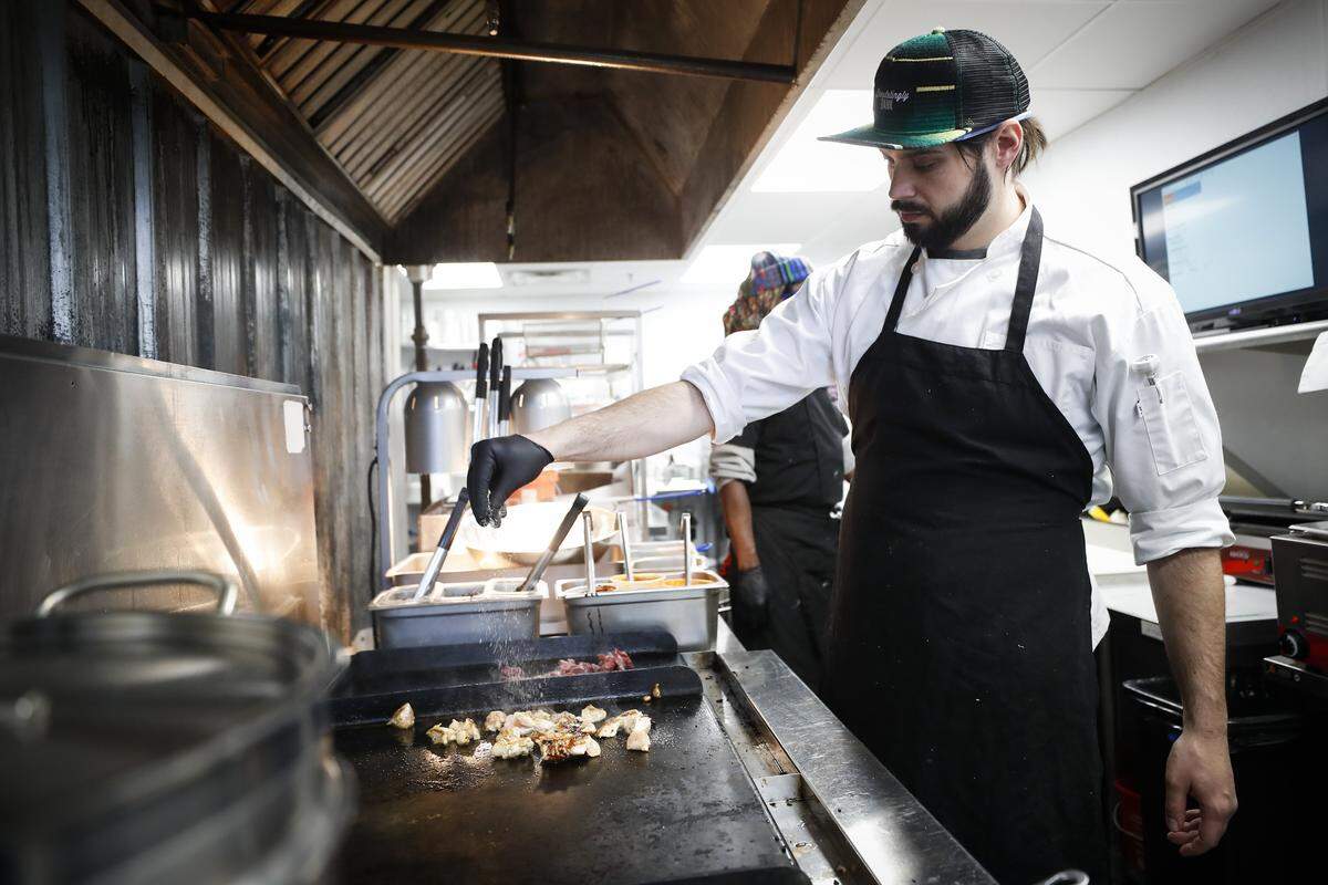Bazaar Eatery executive chef and co-owner Mitch Boggs seasons chicken for a Shogun Taco Friday at Bazaar Eatery located inside Ethereal Brewing Public House.