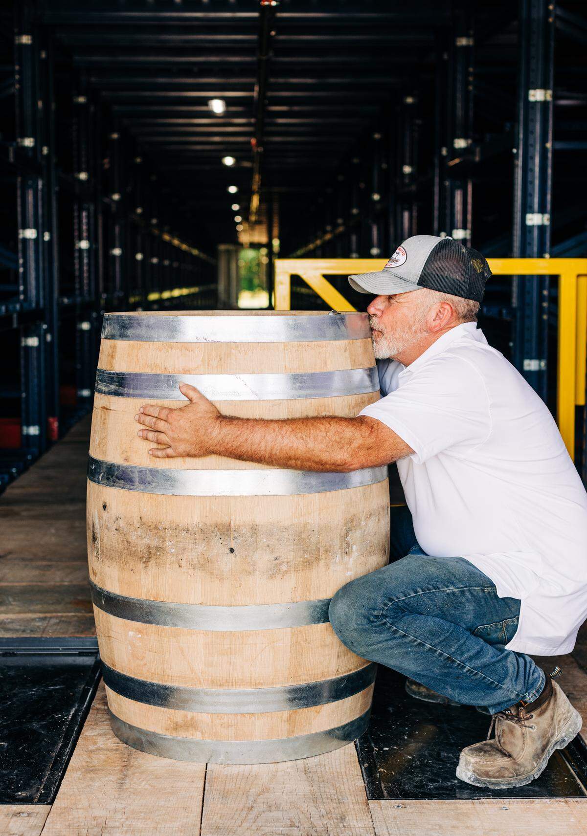 Assistant master distiller Terry Ballard, embracing a newly filled barrel, joined Jackson Purchase after leaving Willett Distillery.