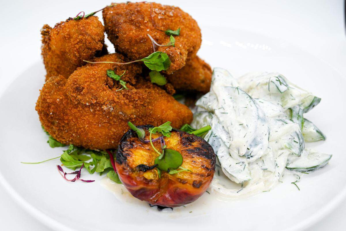 Salt & Vinegar’s fried chicken is quartered whole Cornish game hen with Chile and herb infused honey, cucumber salad and Bruleed seasoned fruit.