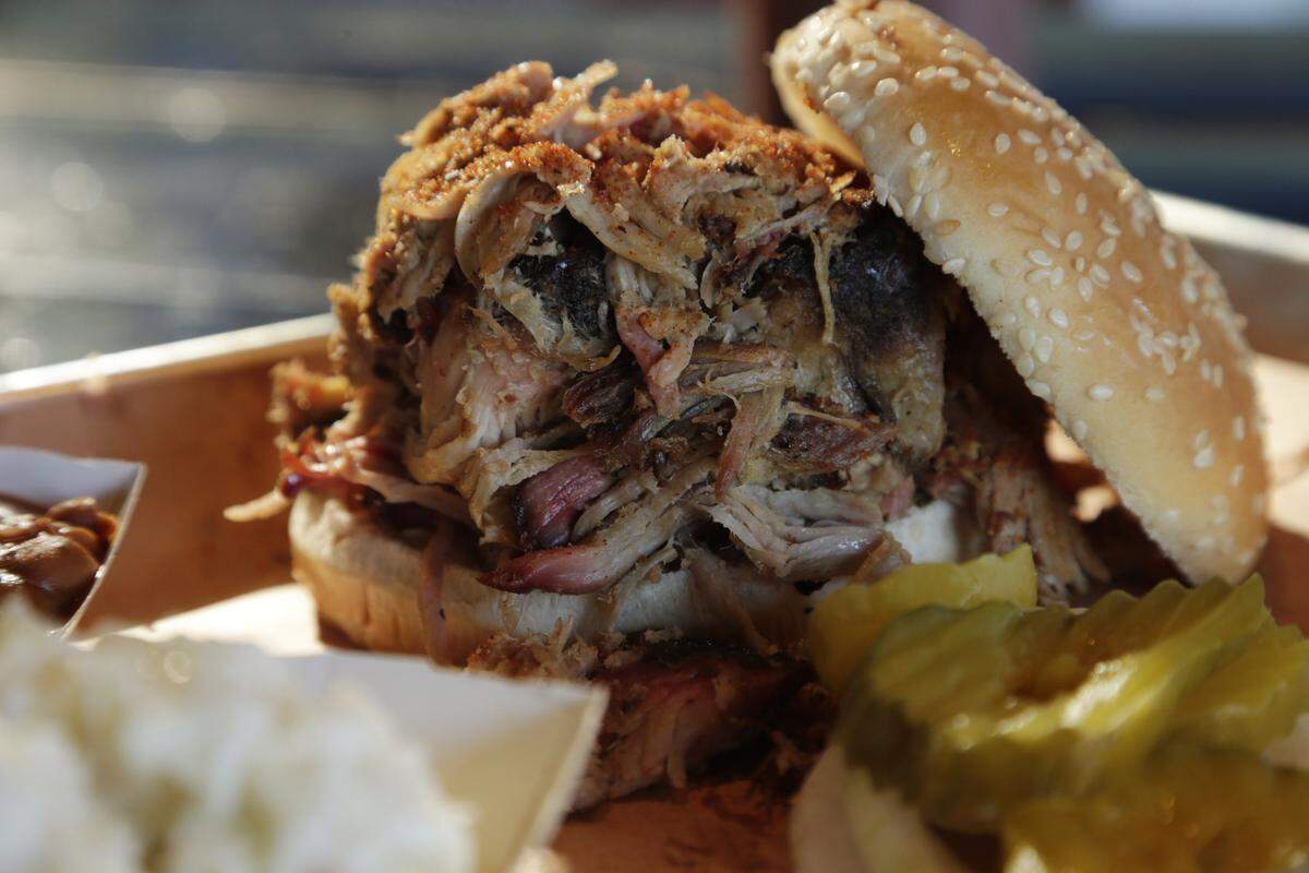 A pulled pork sandwich with ranch beans and coleslaw at the Blue Door Smokehouse on Walton Avenue. The restaurant will be moving at the end of 2023.