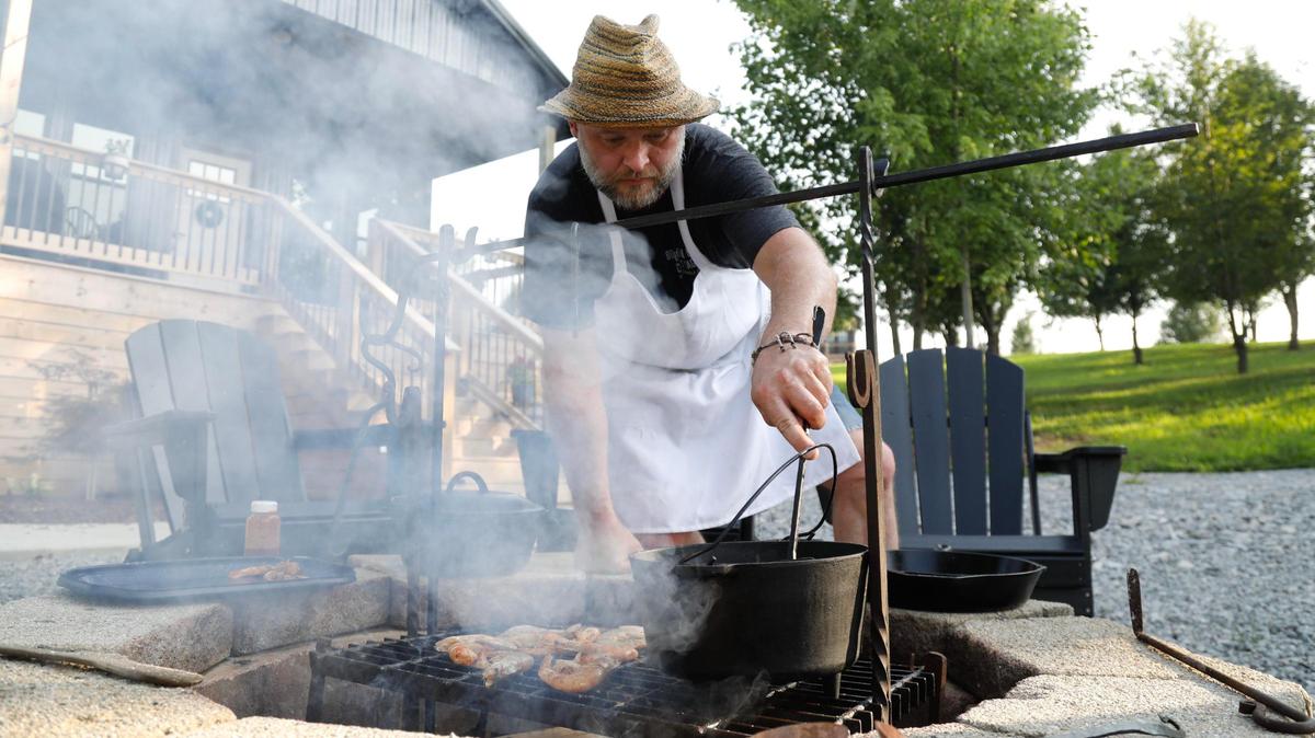 Tony Miller stirs butter, garlic and lemon juice that the prawns will be tossed once they are finished cooking on Tuesday, July 25, 2023 at Bourbon Barrel Cottages in Lawrenceburg, Ky.