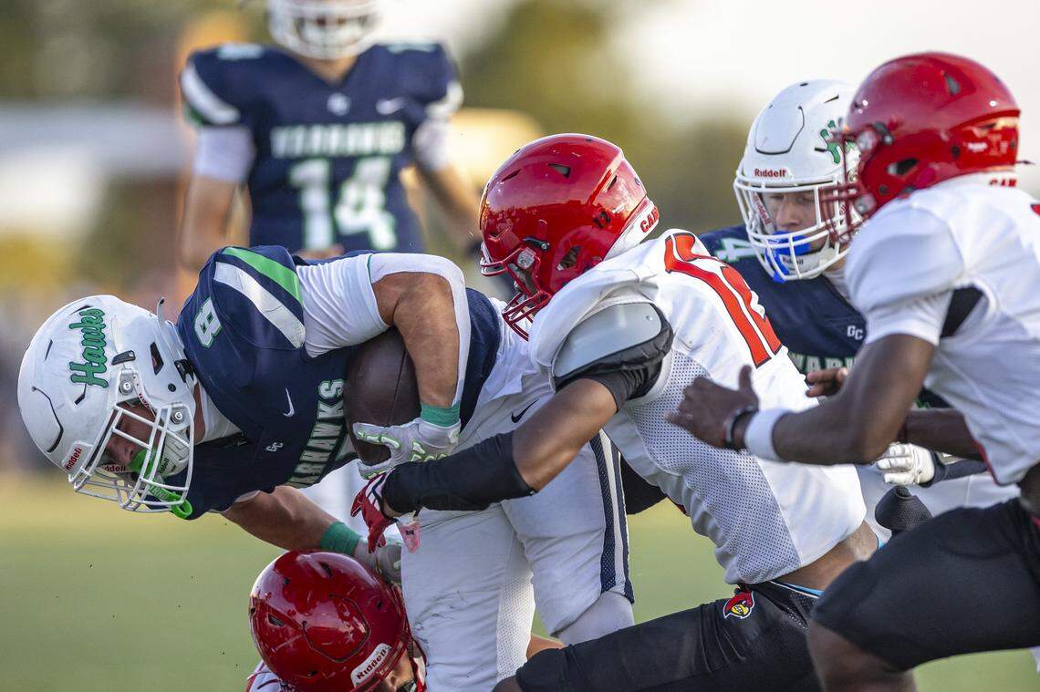 Great Crossing's Luke Ballard (8) is wrapped up by Scott County's Ju Ju Harmon (12) during a game at Great Crossing High School Birds Nest in Georgetown, Ky., on Friday, Aug. 29, 2025.