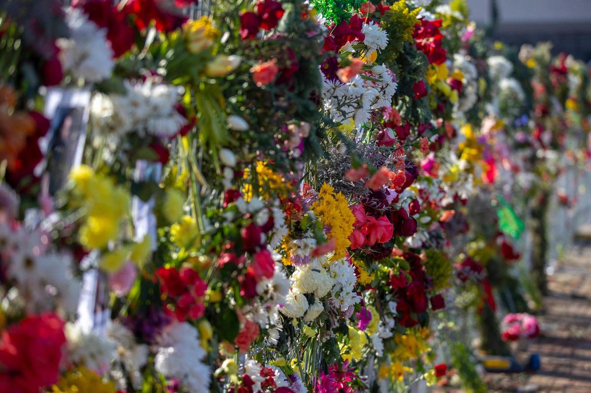 Flowers are placed on a temporary fence outside the Graves County Courthouse in Mayfield, Ky., on Monday, Dec. 20, 2021.