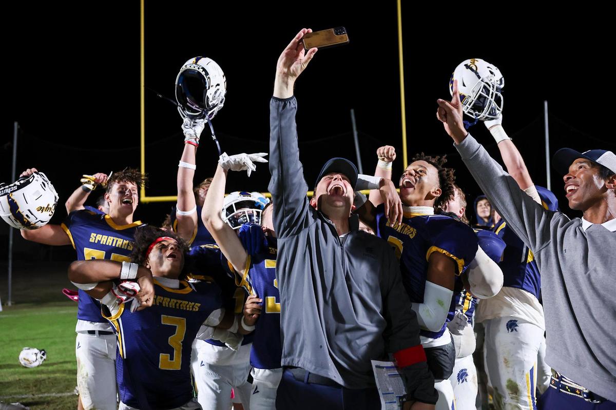 Sayre head coach Chad Pennington got out his phone to help celebrate a 12-8 win over Eminence to help clinch the Spartans’ first football district championship at Sayre Athletic Complex in 2023.
