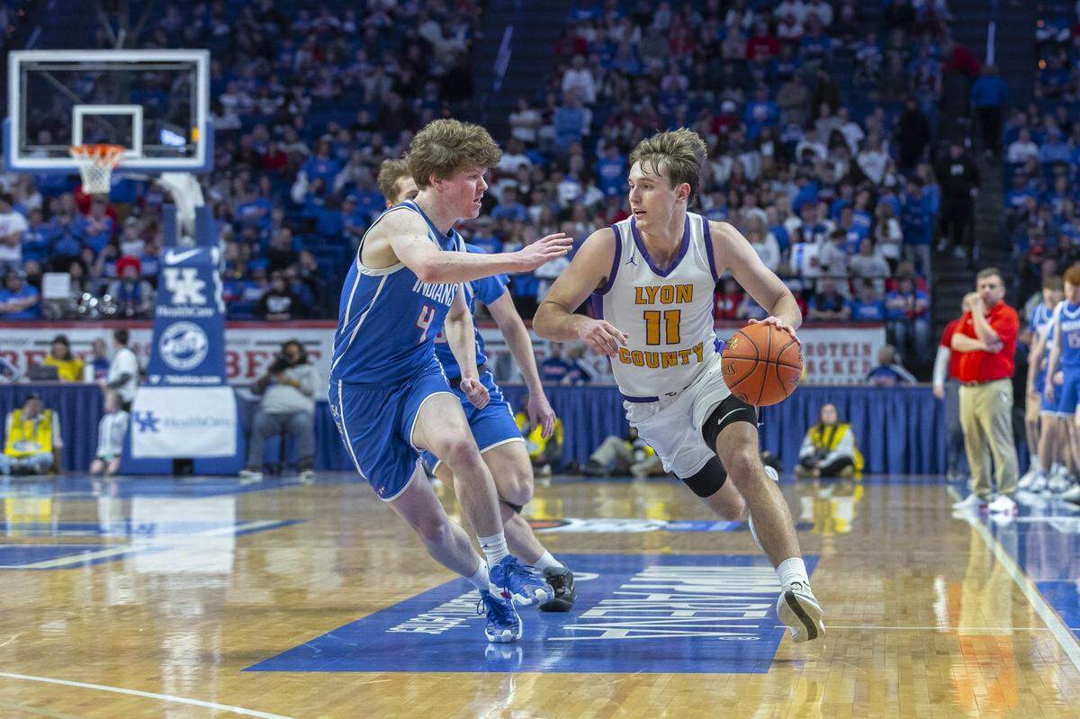 Kentucky Mr. Basketball Travis Perry (11) drives against Adair County’s Carter White on Friday. Perry led Lyon County with 21 points in the quarterfinal win.