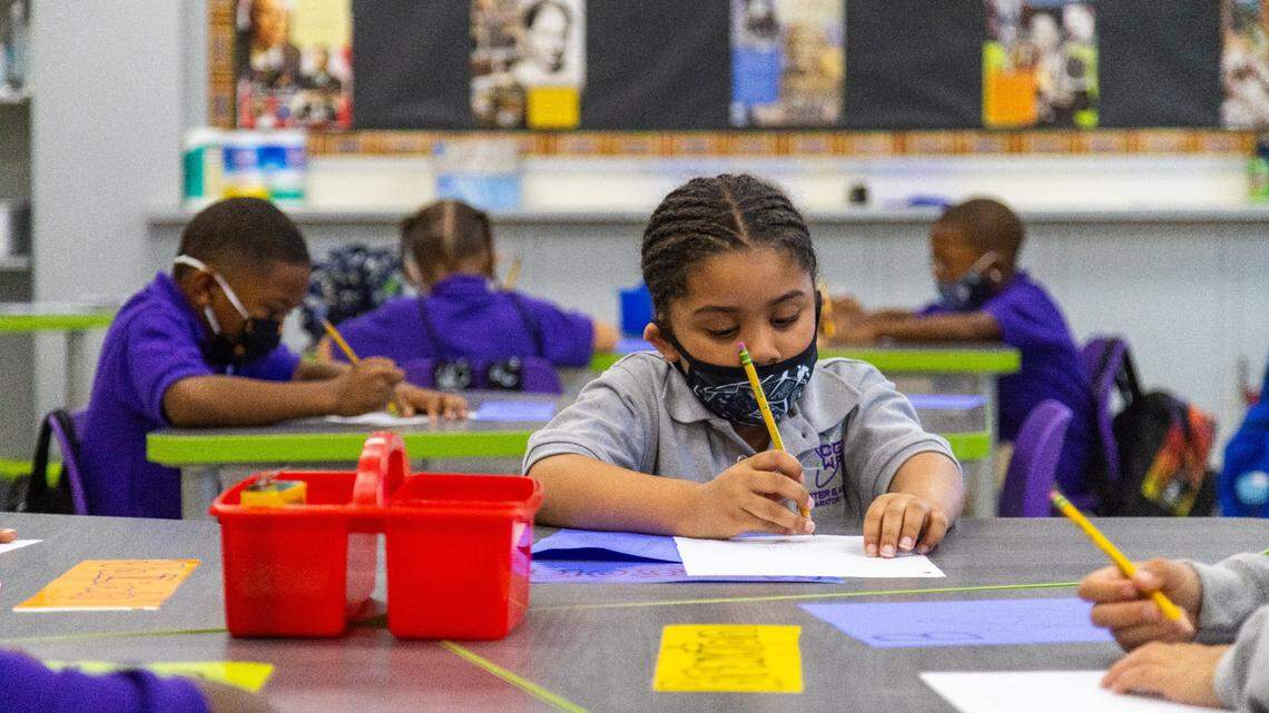 A first grade class of Carter G Woodson Preparatory Academy completes an assignment of describing their community on their first day of school, August 11, 2021.