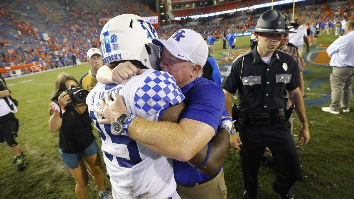 Kentucky safety Darius West (25) got a hug from Coach Mark Stoops after the Cats’ 27-16 victory at Florida.