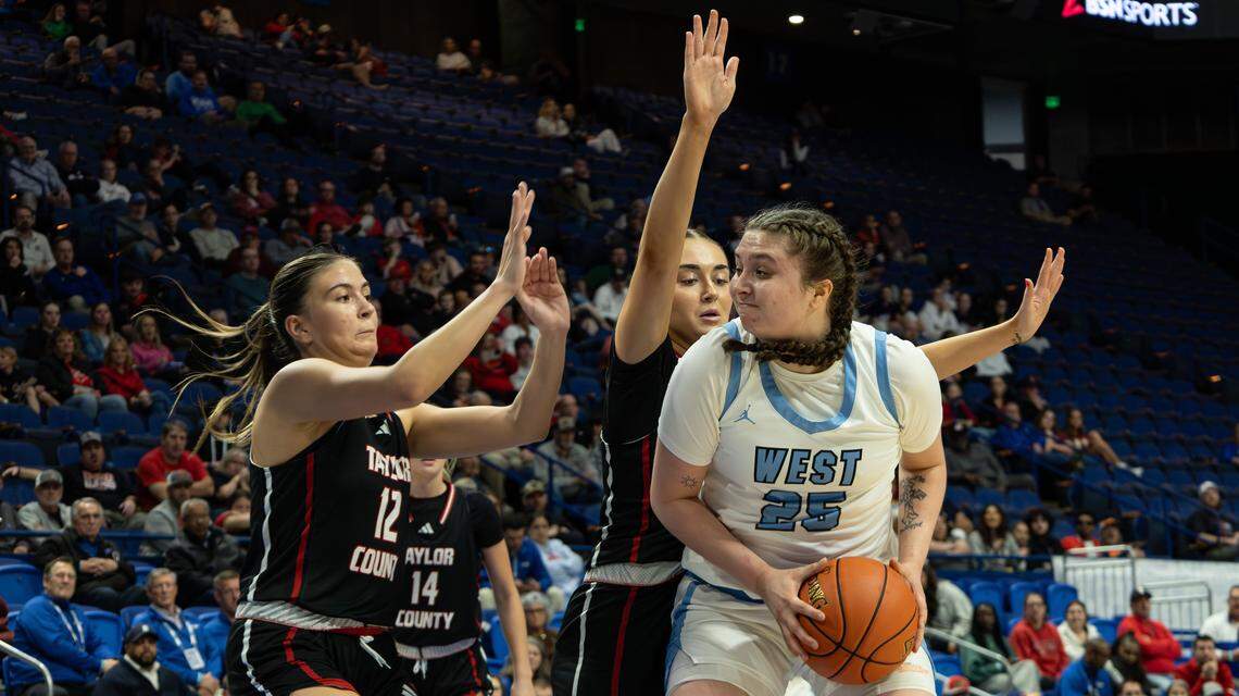 Taylor County's Avery Raikes assists teammate Kallie Vaughn in blocking West Jessamine's Kimberly Johnson during the 2026 Clark's Pump-N-Shop Girls' Basketball Sweet 16 state tournament first-round game between West Jessamine and Taylor County at Rupp Arena on March 11, 2026, in Lexington, Ky.