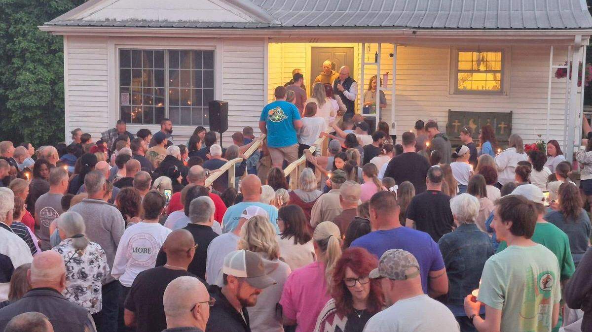 Hundreds of people gather for a prayer service in front of the home of the Stanford, Ky., mayor.