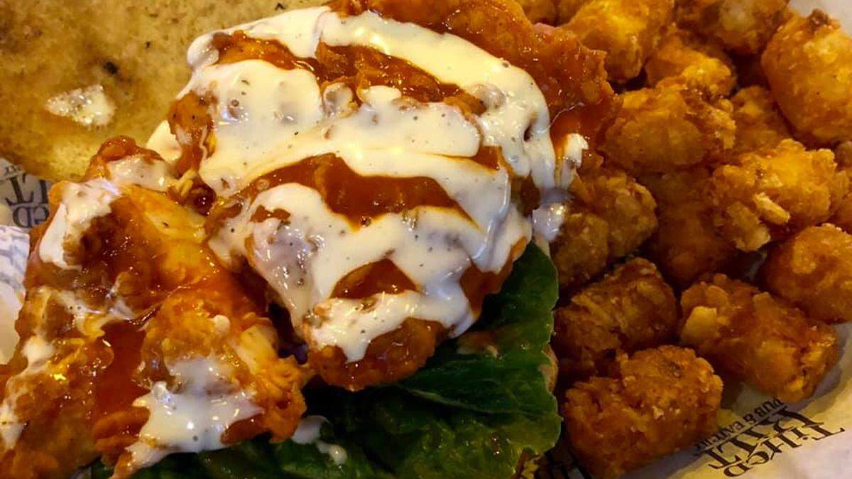 The Spicy Mother Clucker Chicken Sandwich and tots at Tilted Kilt, which has opened next to KSBar and Grille just off South Broadway.