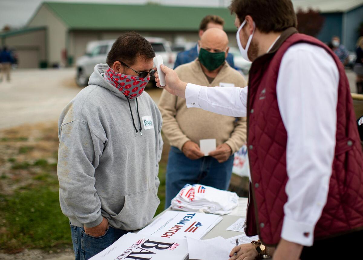 A man has his temperature taken before attending a campaign event for Senate majority leader Mitch McConnell in front of Custom Tool and Manufacturing in Lawrenceburg, Ky., Wednesday, October 28, 2020.