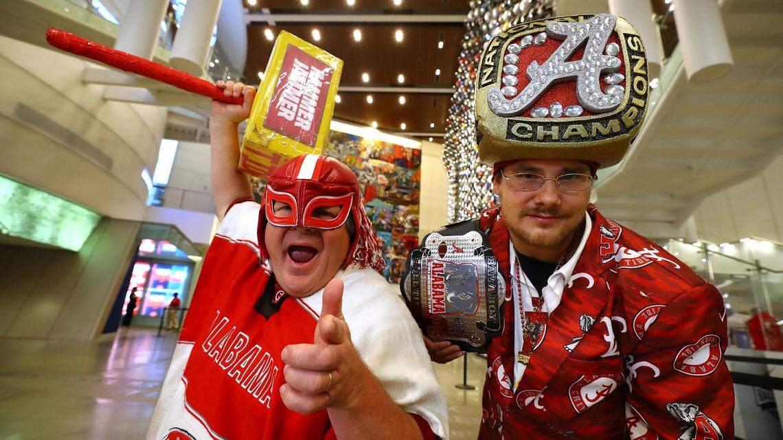 Alabama fans Buck “Nacho Alabama” Smith, left, and Shannon “Ring” Villa wait for the arrival of Alabama head coach Nick Saban at SEC Media Days in Atlanta on Tuesday.