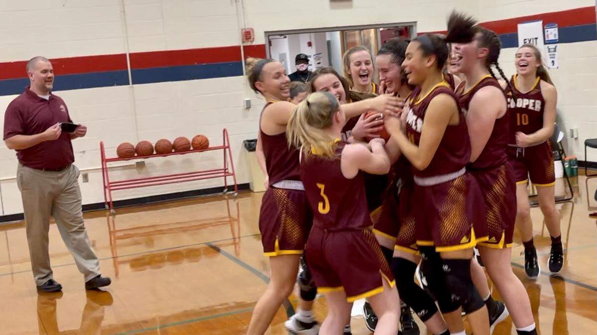 Cooper Coach Justin Holthaus, left, watched as his Jaguars’ team celebrated their teammate Whitney Lind’s 1,000th career point and a victory over then-No. 2 Sacred Heart on Saturday at Butler Traditional High School in Louisville. Lind, center with ball, led the team with 20 points.